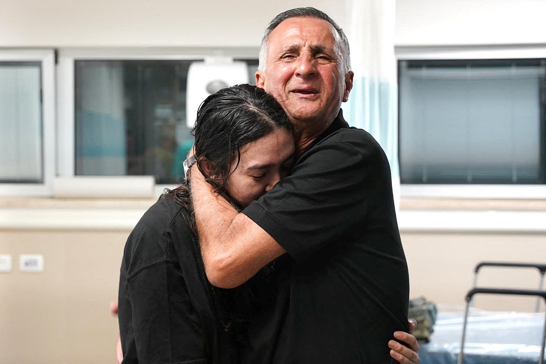 Cette photo diffusée par l'armée israélienne le 8 juin 2024 montre Noa Argamani, 26 ans, serrée dans les bras de son père au centre médical Sheba Tel-HaShomer, après son sauvetage de la bande de Gaza par l'armée israélienne, à Ramat Gan près de Tel Aviv le 8 juin 2024. (Photo distribuée Armée israélienne AFP)