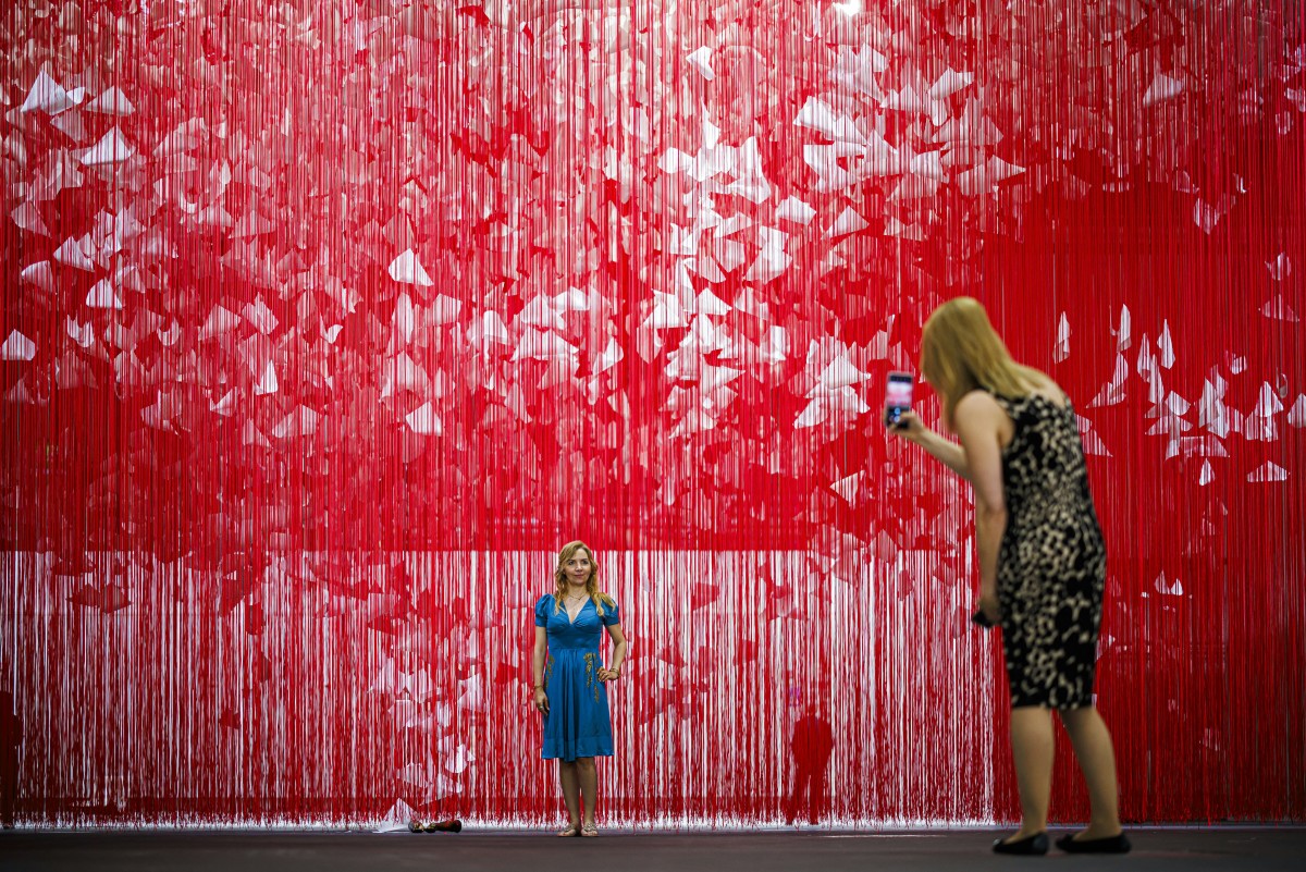 Un visiteur prend une photo de "The Extended Line" 2023/2024, de l'artiste japonaise Chiharu Shiota exposée dans le secteur Unlimited de la foire d'art moderne et contemporain Art Basel, à Bâle, dans le nord de la Suisse, le 11 juin 2024. (Photo Valentin Flauraud AFP)