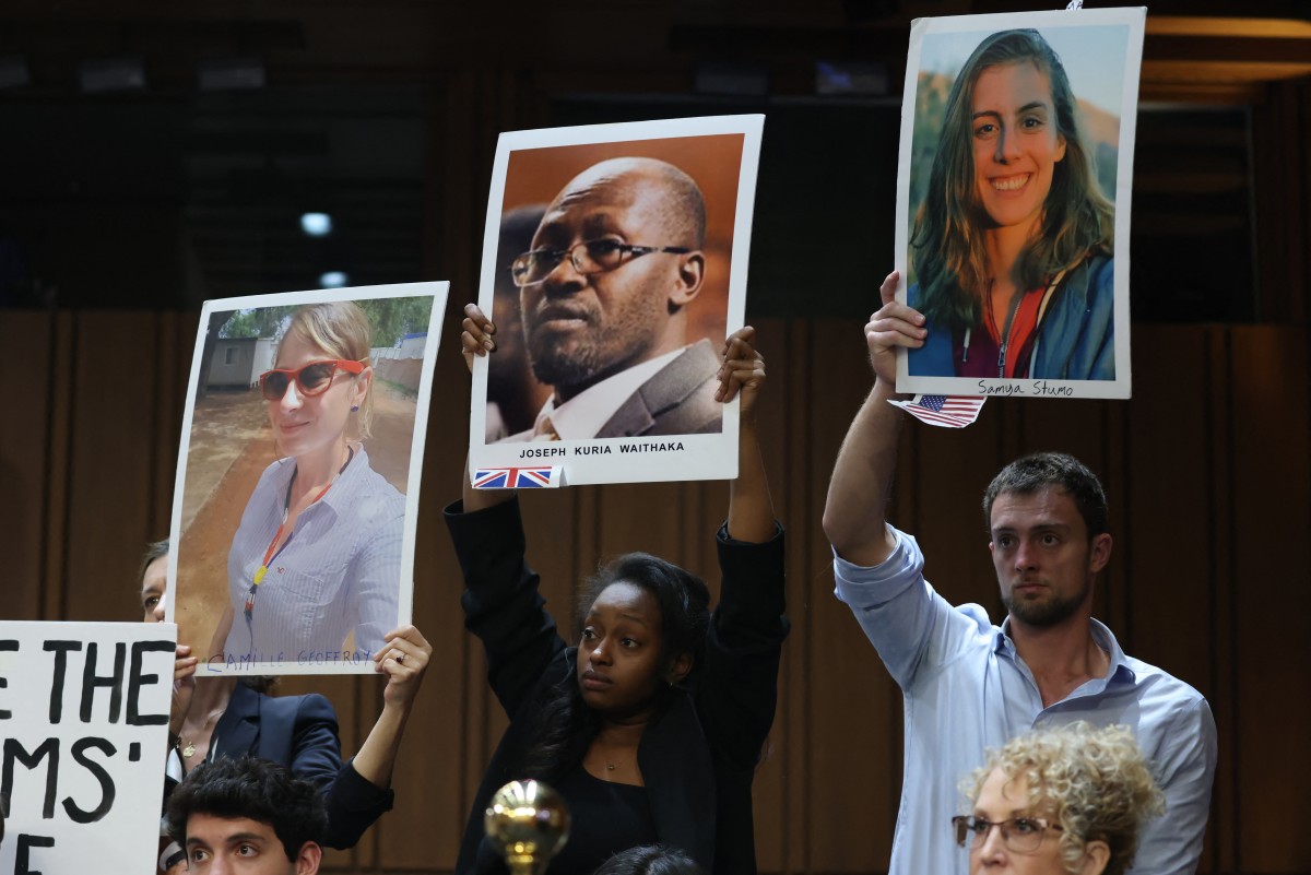 Des personnes brandissent des portraits de victimes alors que le président-directeur général de Boeing, Dave Calhoun, témoigne lors d'une audition de la sous-commission des enquêtes de la commission de la sécurité intérieure et des affaires gouvernementales du Sénat pour examiner "la culture de sécurité brisée de Boeing" au Capitole à Washington, DC, le 18 juin 2024. (Photo par Samuel Corum AFP)