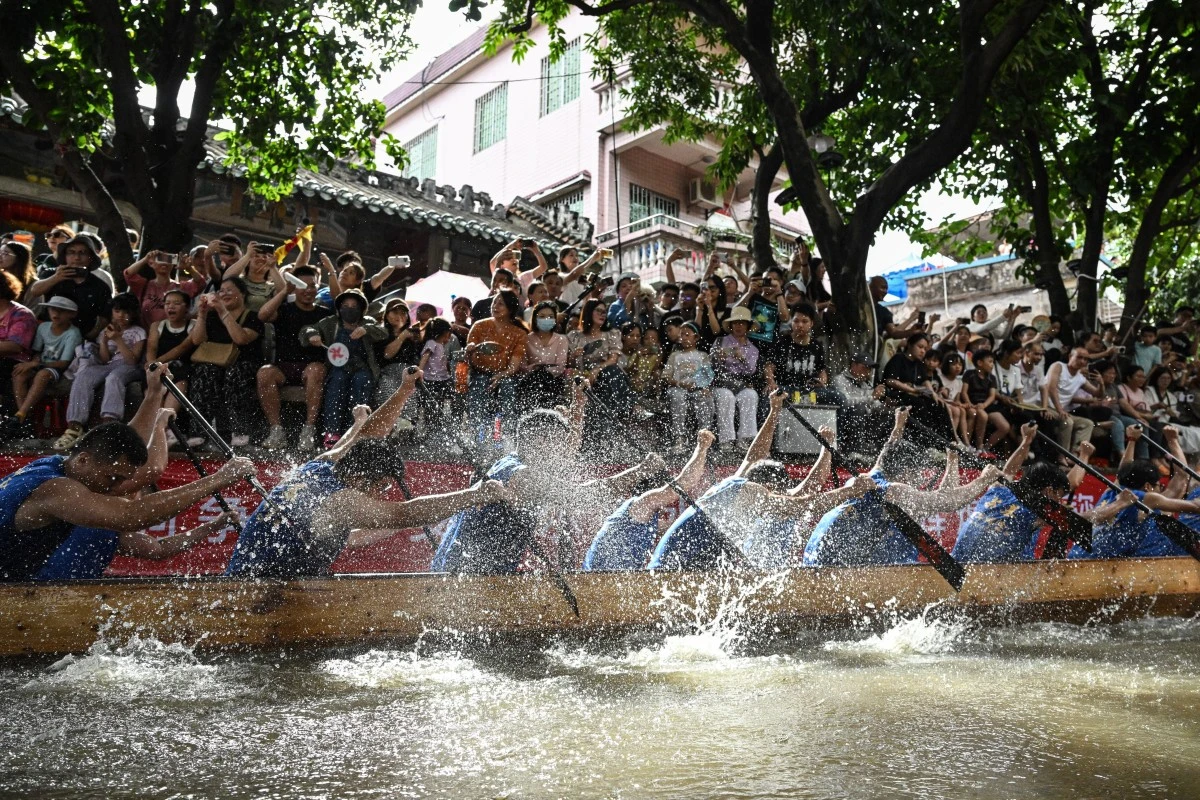 Des habitants participent à des courses de bateaux-dragons dans un canal étroit lors du festival des bateaux-dragons à Foshan, dans la province de Guangdong, dans le sud de la Chine, le 10 juin 2024. (Photo Jade Gao / AFP)