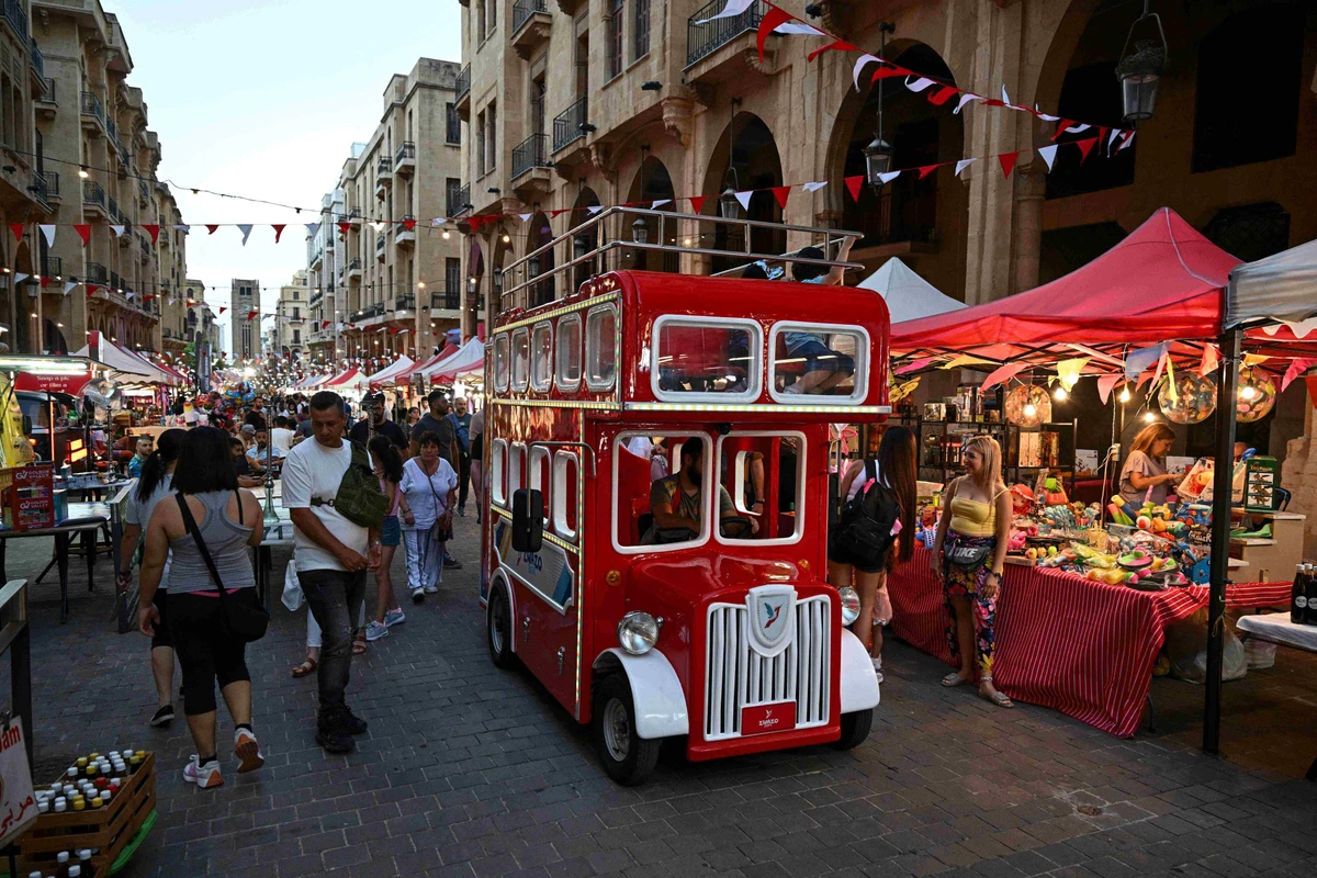Un véhicule habillé comme un bus à deux étages roule près des participants au festival de la rue de Beyrouth, dans le centre-ville de Beyrouth, le 22 juin 2024. (Photo par Joseph EID / AFP)