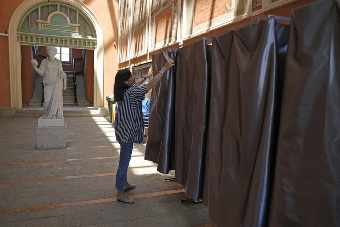 Un employé de mairie installe des isoloirs en vue des prochaines élections législatives françaises (Dossier/AFP)