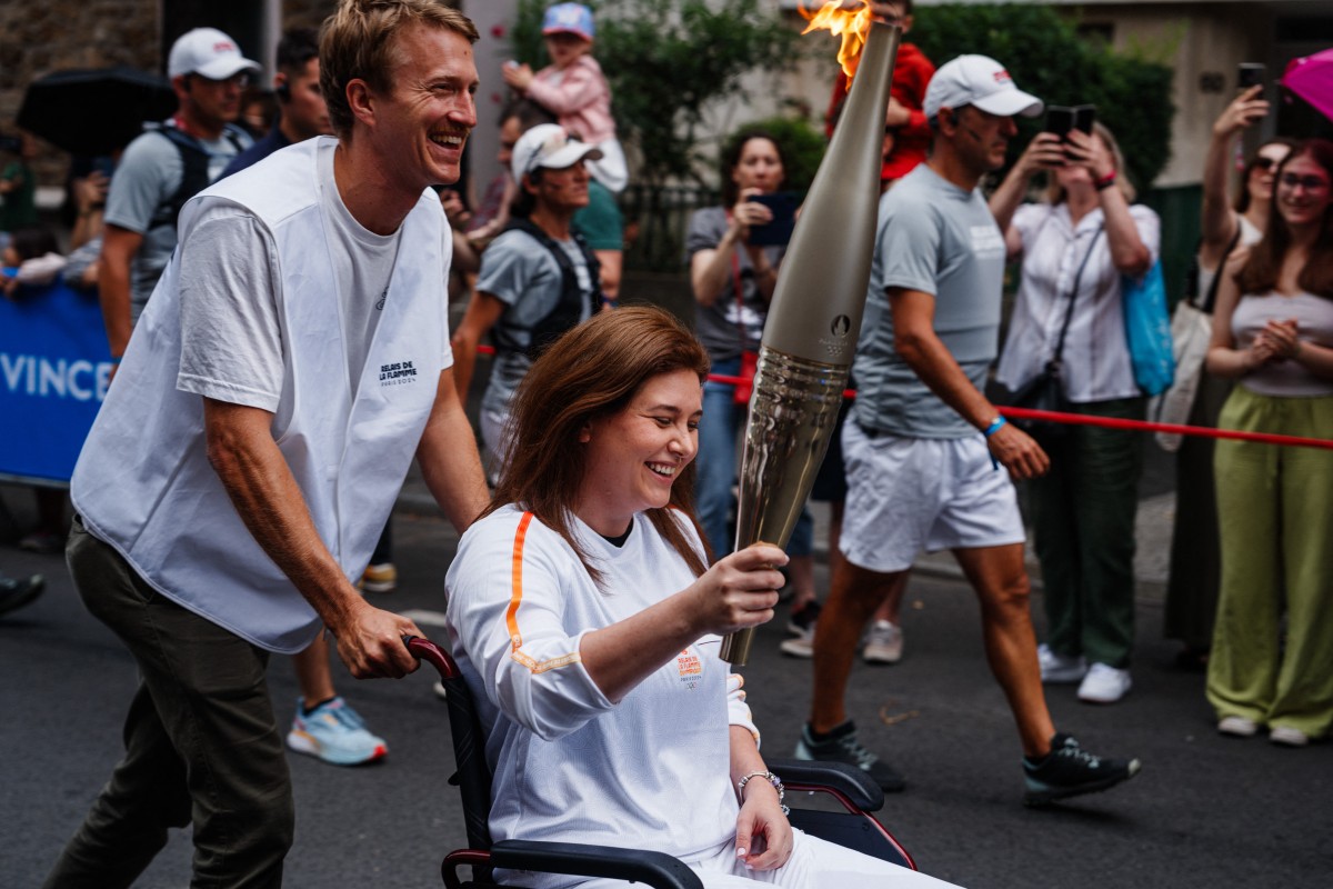 Les journalistes de l'AFP Christina Assi et Dylan Collins, blessés au Liban, portent la flamme olympique