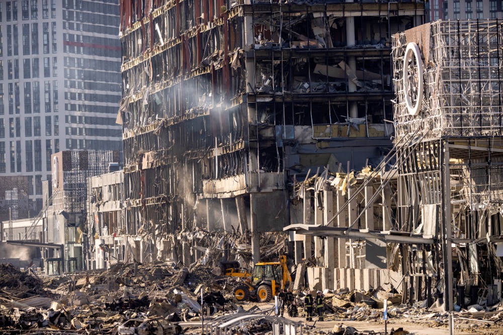 Les pompiers ukrainiens travaillent au milieu des décombres du centre commercial de Retroville, le lendemain du bombardement par les forces russes. (AFP)