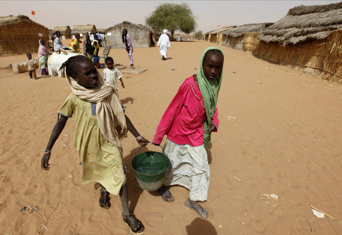 FILE — Sudanese refugee girls carry water supplies near a polling station in the refugee camp of Zamzam, on the outskirts of El Fasher, Darfur, Sudan, on April 13, 2010. (AP)