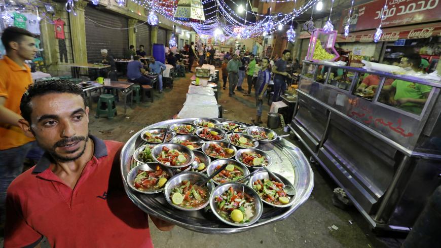 A waiter carries servings of pre-dawn suhoor meals for customers during the Muslim holy month of Ramadan in Cairo, Egypt, May 31, 2018. (Reuters)