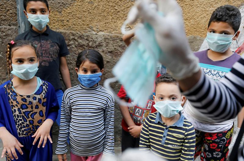 An Egyptian clown shows children how to put on face masks amid the spread of COVID-19, Darb Al-Ahmar, Cairo, Egypt, April 13, 2020. (Reuters)