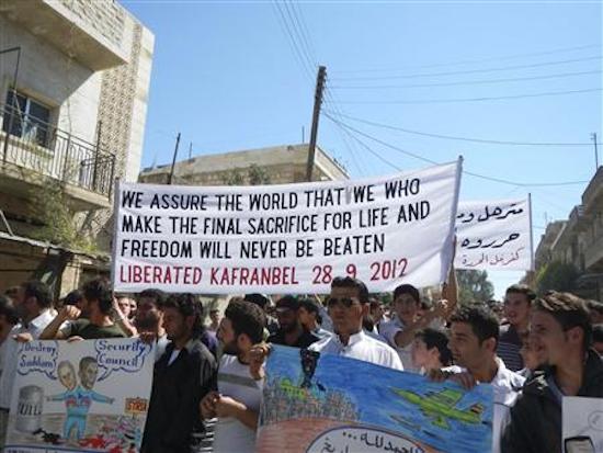 Demonstrators hold a banner during a protest against Syria’s President Bashar Assad in Kafranbel, near Idlib, September 28, 2012. (Reuters)