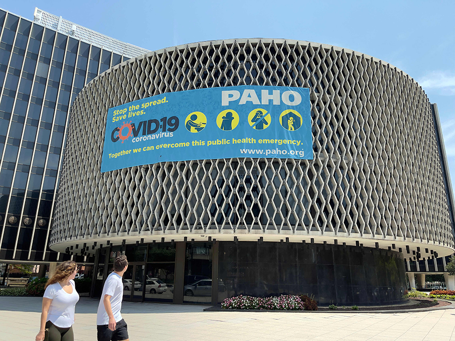 People look at a Covid-19 sign promoting safety measures, posted at the Pan American Health Organization/World Health Organization Building in Washington, DC on August 6, 2021. (AFP)