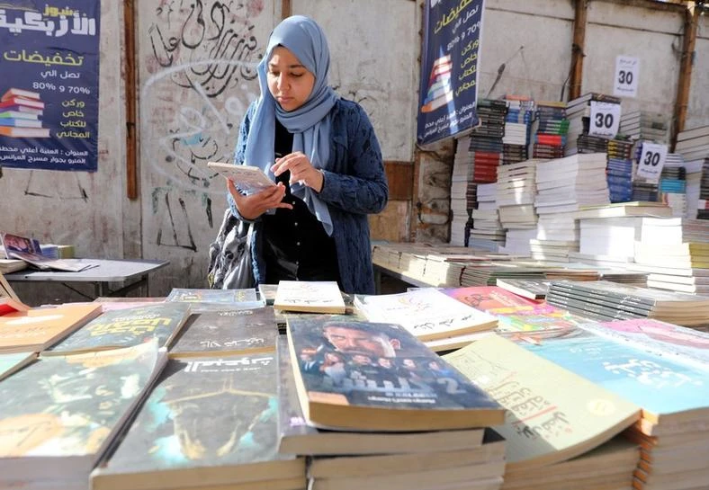 A woman checks a book at the historic Al-Azbakeya book market in Cairo, Egypt, Jan. 15, 2019. (Reuters)