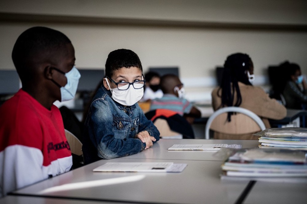 pupils wearing protective masks sit in a classroom in a middle school in Bron, south-eastern France. (AFP/File)