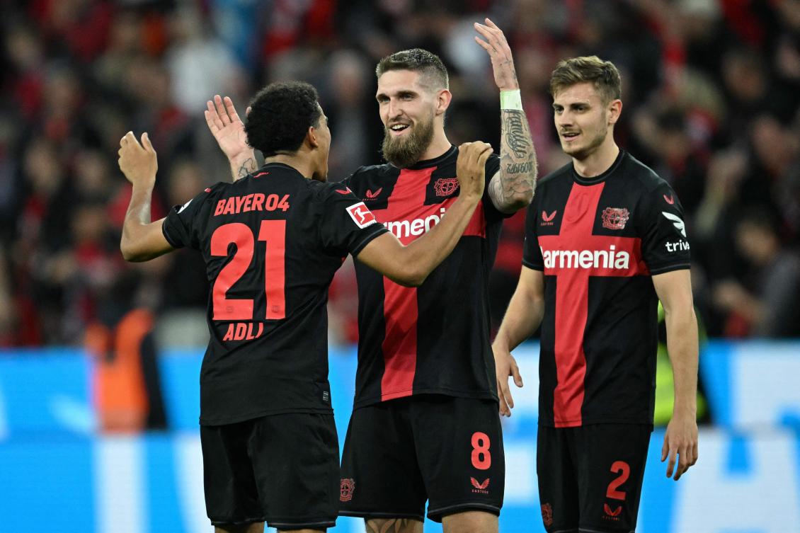 Bayer Leverkusen’s French forward Amine Adli, German midfielder Andrich and Croatian defender Josip Stanisic celebrate after their Bundesliga match against VfL Stuttgart in Leverkusen, on Apr. 27, 2024. (AFP)