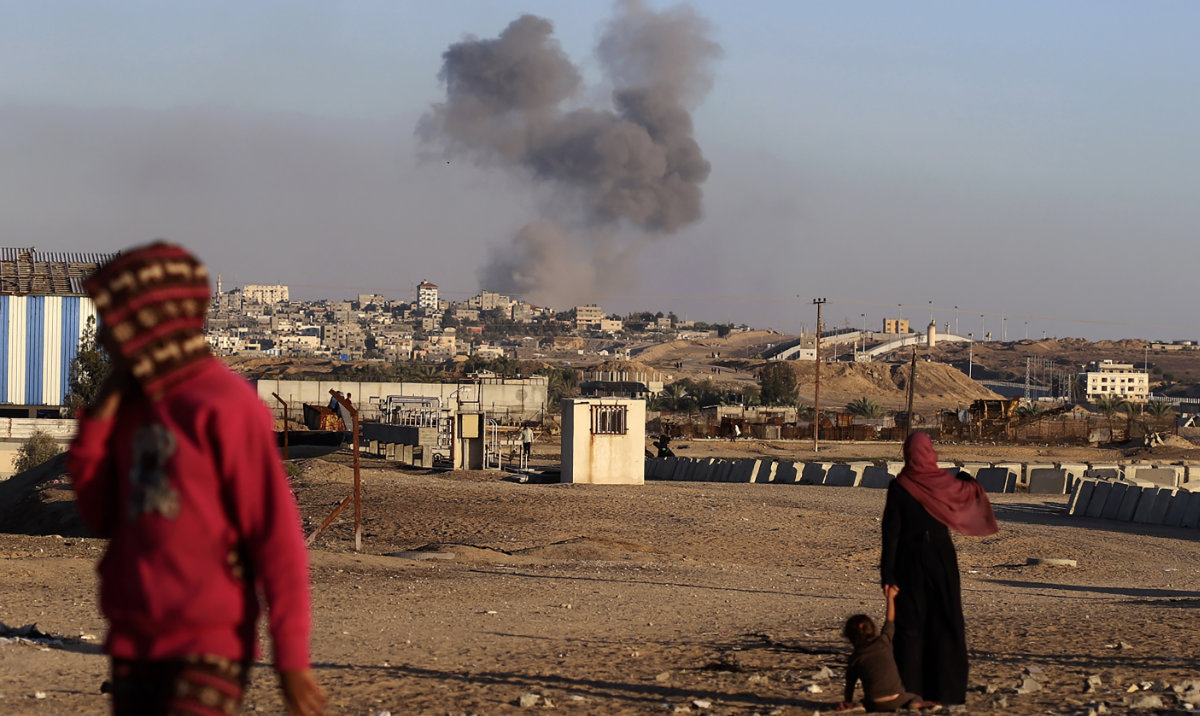 Smoke rises following an Israeli airstrike on buildings near the separating wall between Egypt and Rafah. (AP)
