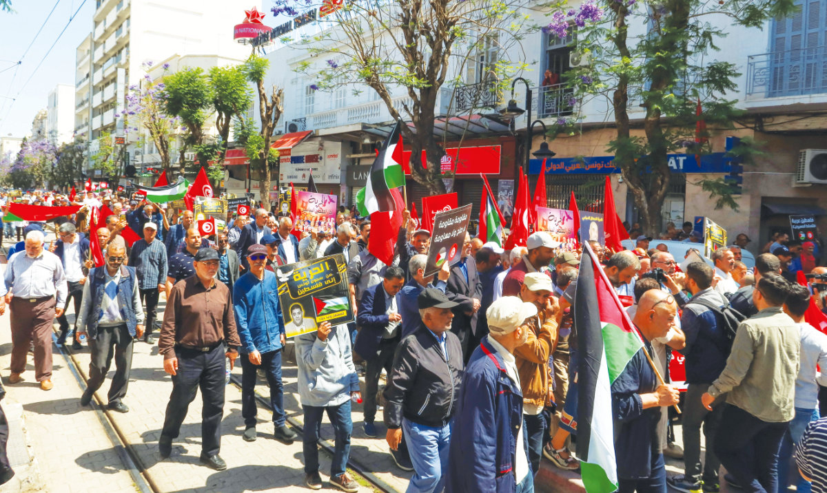 Demonstrators hold flags and signs during a protest demanding the release of imprisoned journalists, activists, opposition figures in Tunis on Monday. (Reuters)