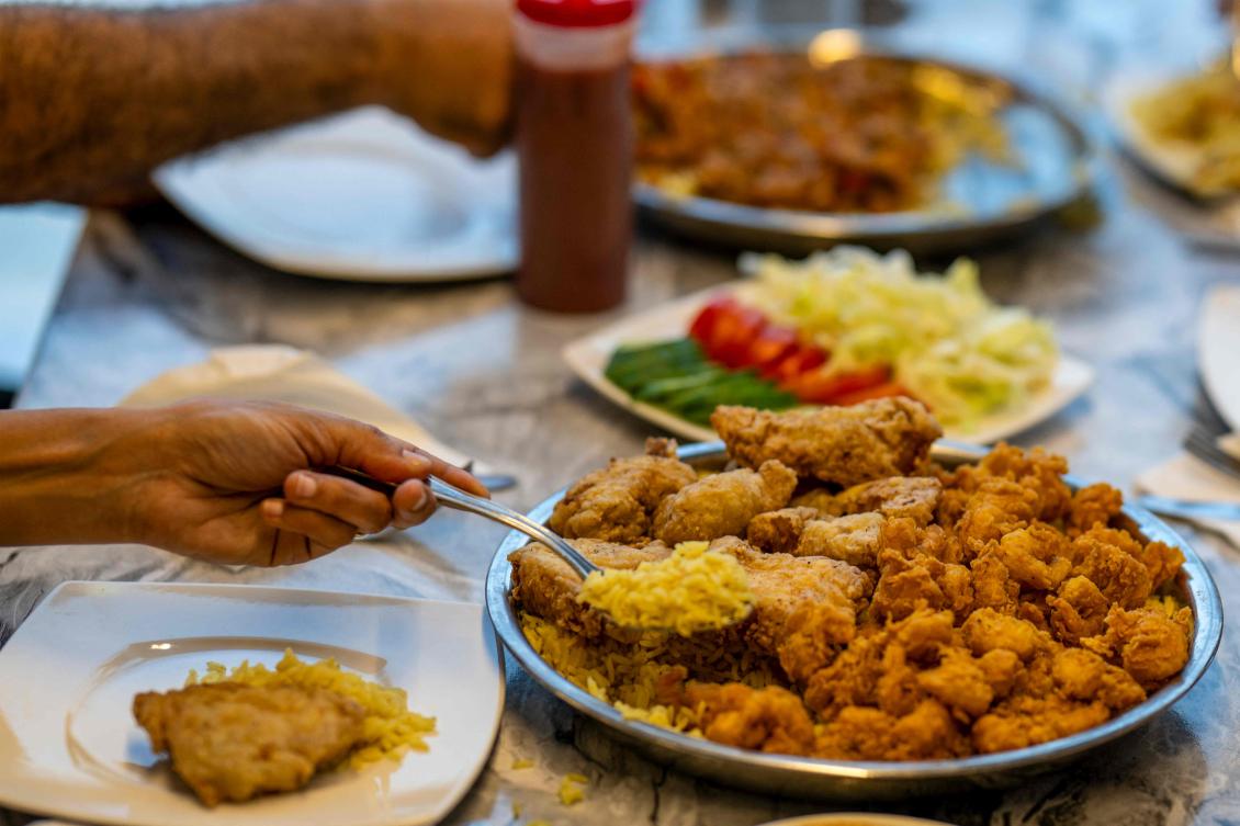 Clients are served traditional Sudanese food at a restaurant run by a businesswoman who relocated to the Egyptian capital Cairo after fleeing the ongoing war in Sudan on May 21, 2024. (AFP)