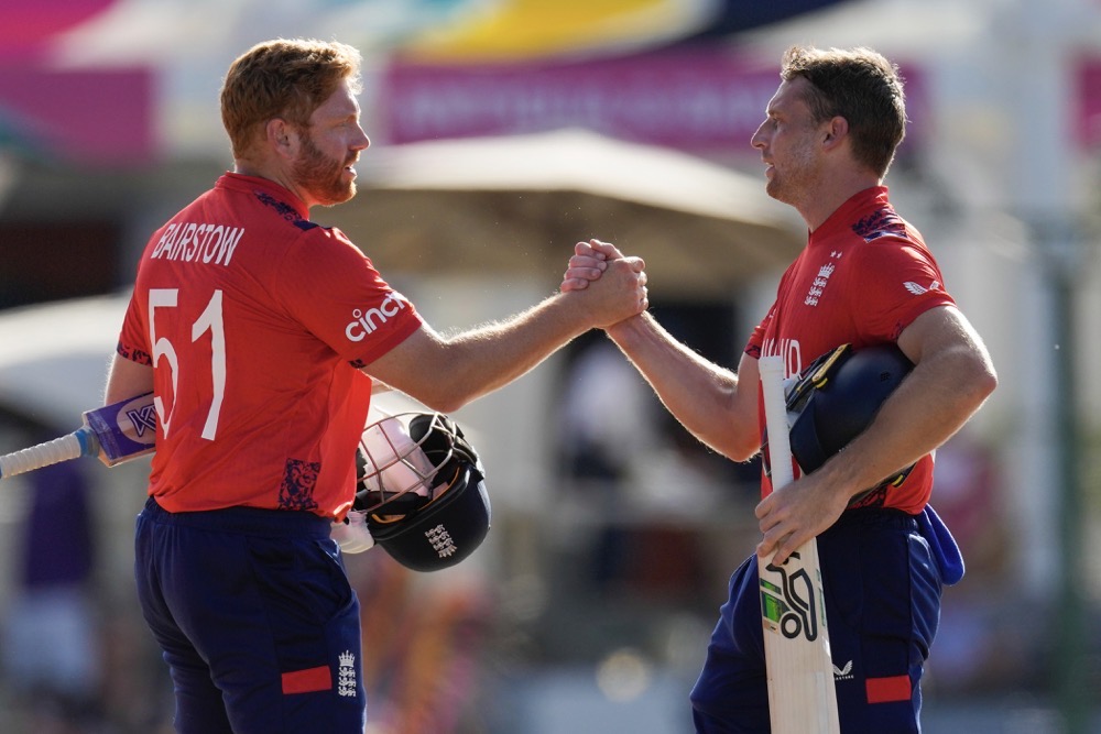 England's captain Jos Buttler, right, and batting partner Jonny Bairstow shake hands at the end of the ICC Men's T20 World Cup cricket match against Oman at Sir Vivian Richards Stadium in North Sound, Antigua and Barbuda on June 13, 2024. (AP)