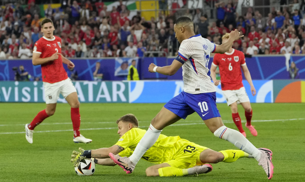 Austria's goalkeeper Patrick Pentz catches the ball next to Kylian Mbappe of France during a Group D match between Austria and France at the Euro 2024 soccer tournament in Duesseldorf, Germany, Monday, June 17, 2024. (AP)