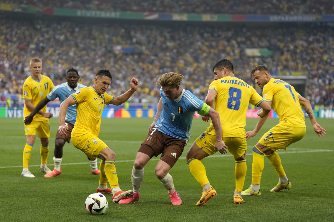 Belgium’s Kevin De Bruyne fights for the ball with Ukraine’s Ruslan Malinovskyi and Andriy Yarmolenko during their Euro 2024 Group E match in Stuttgart on Jun. 26, 2024. (AP)