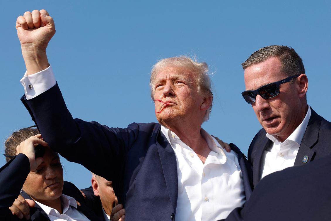 Republican presidential candidate former President Donald Trump pumps his fist as he is rushed offstage during a rally on July 13, 2024 in Butler, Pennsylvania. (AFP)