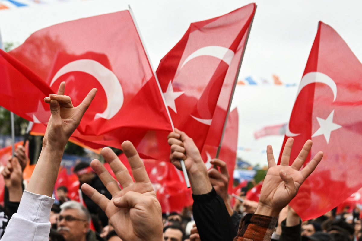 Supporters of Turkiye's ruling Justice and Development (AK) Party wave Turkish national flags flash the "grey wolf" sign as they attend a campaign rally in the Sultangazi district of Istanbul on May 12, 2023. (AFP)