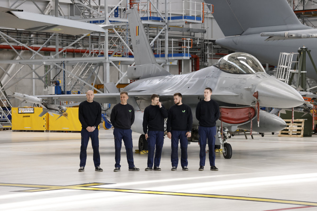 Ukrainian mechanics stand next to an F-16 fighter jet at Belgium's Melsbroek military airport on May 28, 2024. (AFP/File)