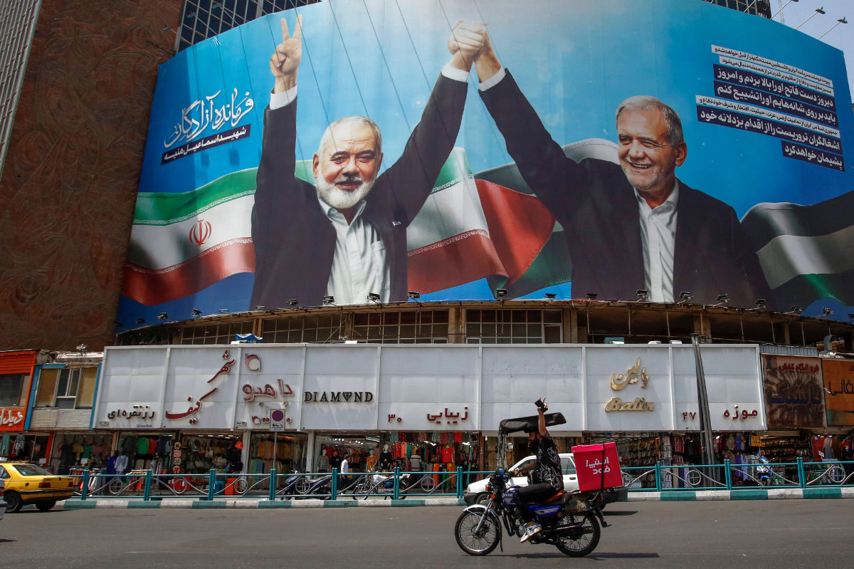 Iran's President Masoud Pezeshkian (R) and slain leader Hamas leader Ismail Haniyeh are depicted on a billboard at Tehran. (AFP)