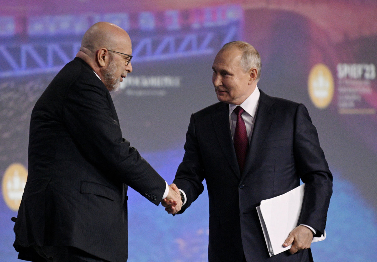 Russian President Vladimir Putin shakes hands with moderator Dimitri Simes during a session of the St. Petersburg International Economic Forum (SPIEF) in Saint Petersburg, Russia, on June 16, 2023. (RIA Novosti via REUTERS)