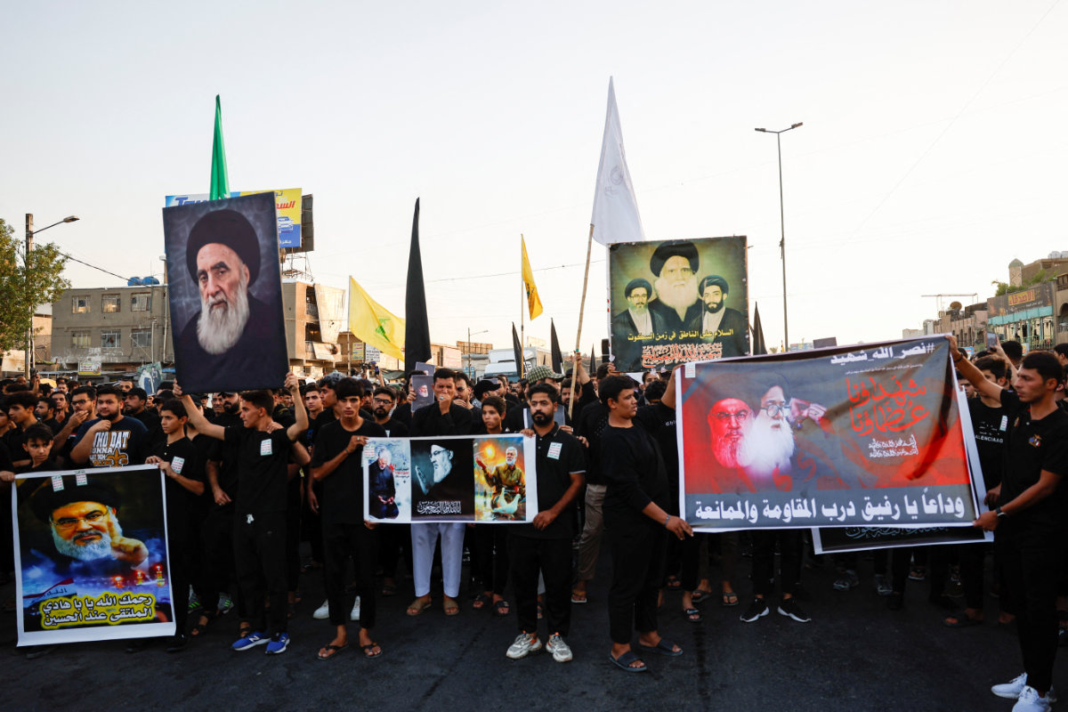People hold posters of Nasrallah during a symbolic funeral in Baghdad on Sept. 29, 2024. (REUTERS)