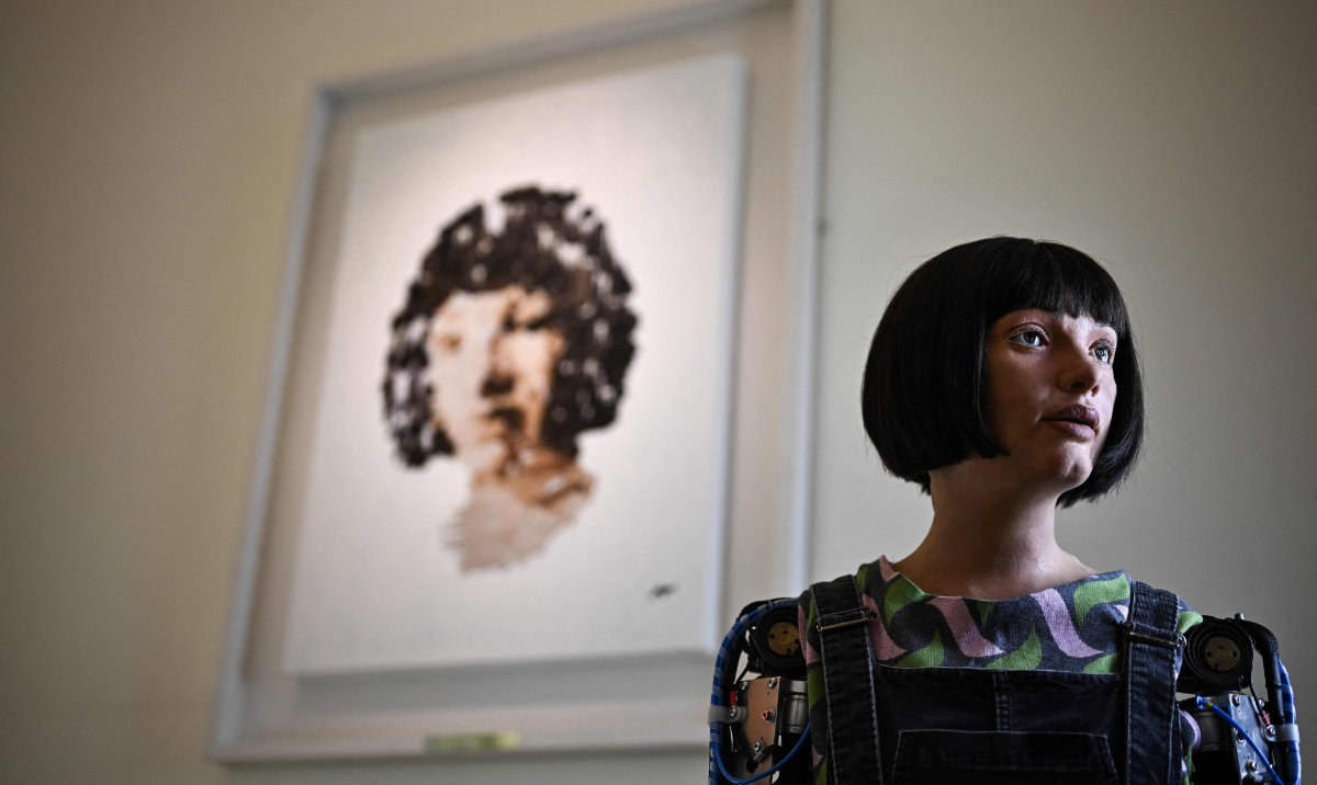 Ultra-realistic AI robot Ai-Da poses in front of a painting she made during the press preview of the London Design Biennale 2023 at Somerset House, central London, on June 1, 2023. The robot artist Ai-Da, a humanoid powered by artificial intelligence, will on October 16, 2024 be the first of its kind to have a painting sold at a major auction house. (AFP)