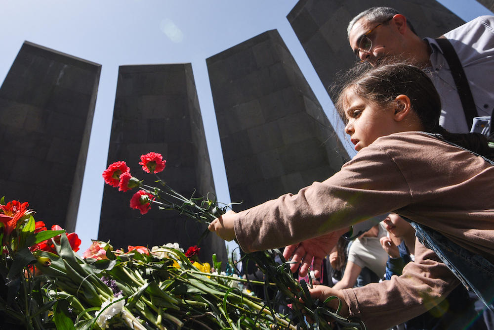 A young girl lays flowers at the Tsitsernakaberd Memorial in Yerevan on April 24, 2022 as Armenians mark the 107th anniversary of WWI-era mass killings as the Ottoman Empire collapsed. (AFP file photo)