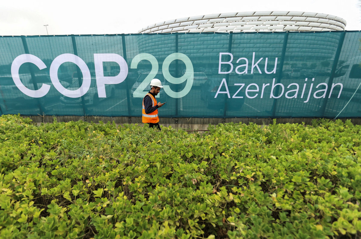 A worker walks along a fence near the Baku Olympic Stadium, the venue of the COP29 United Nations Climate Change Conference, in Baku, Azerbaijan. Just weeks before the summit, the Internet is being swamped with disinformation on climate change and Google is being blamed for not taking action despite its promise to crack down. (REUTERS)