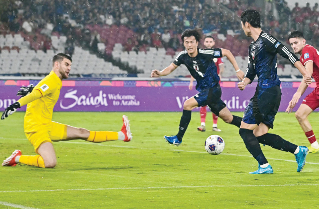 Japan’s Daichi Kamada, right, passes the ball to teammate Koki Ogawa, center, who scores his team’s first goal during the 2026 World Cup Asian Group C qualification match between Indonesia and Japan at the Gelora Bung Karno Stadium in Jakarta on Friday. (AFP)