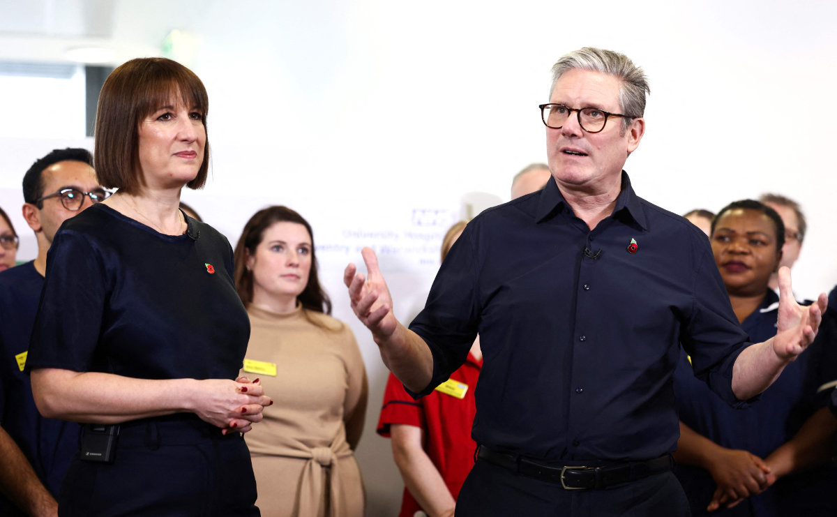 Britain's PM Keir Starmer (R) and Chancellor Rachel Reeves (L) speak with hospital staff in Coventry on Oct.31, 2024. (AFP)