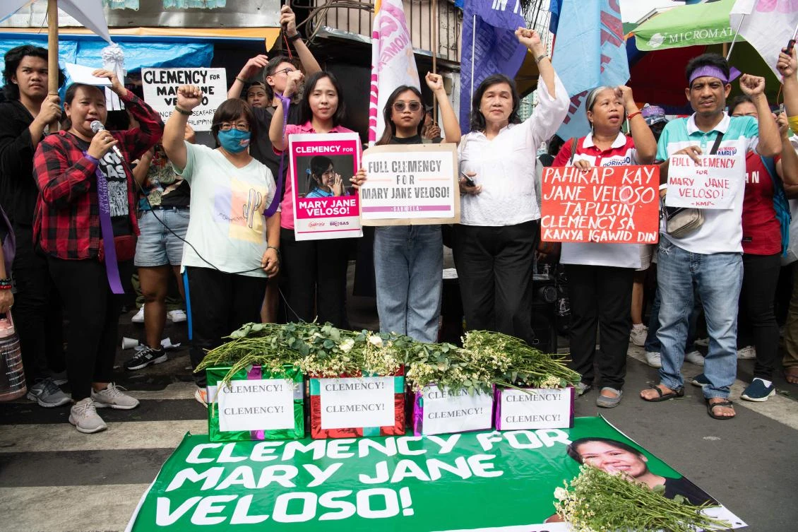 Protesters and supporters of Mary Jane Veloso raise their fists during a protest outside the prison facilities at the Correctional Institution for Women in Manila on December 18, 2024. (AFP)