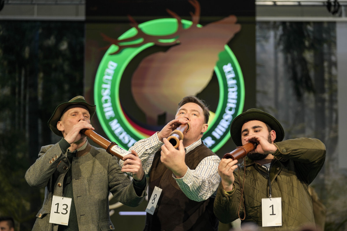 Winner Fabian Menzel, center, 2nd placed Thomas Soltwedel, left, and 3rd placed Jerome Boehm perform to imitate a stag in heat at the German Championship of Deer-Calling at the hunting fair in Dortmund, Germany, on Jan. 31, 2025. (AP)