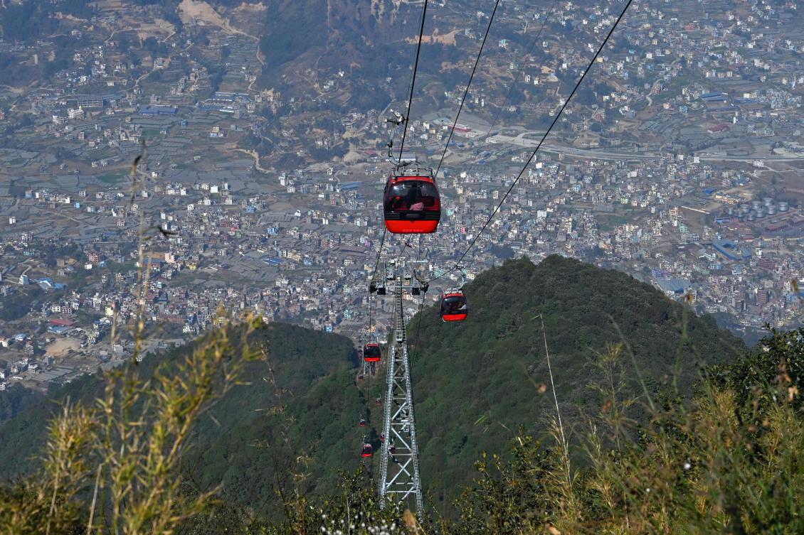 Above, people ride cable cars over the Chandragiri hilltop, on outskirts of Katmandu. (AFP)