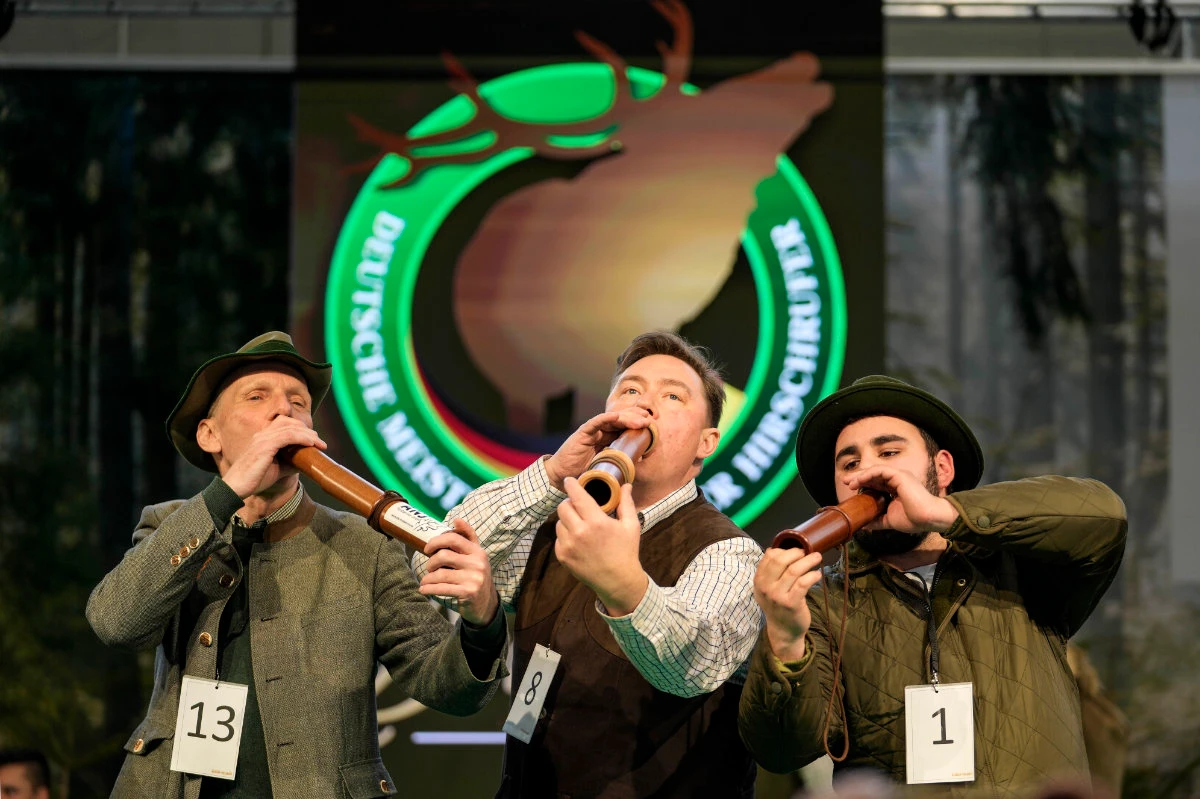 Winner Fabian Menzel, center, 2nd placed Thomas Soltwedel, left, and 3rd placed Jerome Boehm perform to imitate a stag in heat at the German Championship of Deer-Calling at the hunting fair in Dortmund, Germany, on Jan. 31, 2025. (AP)