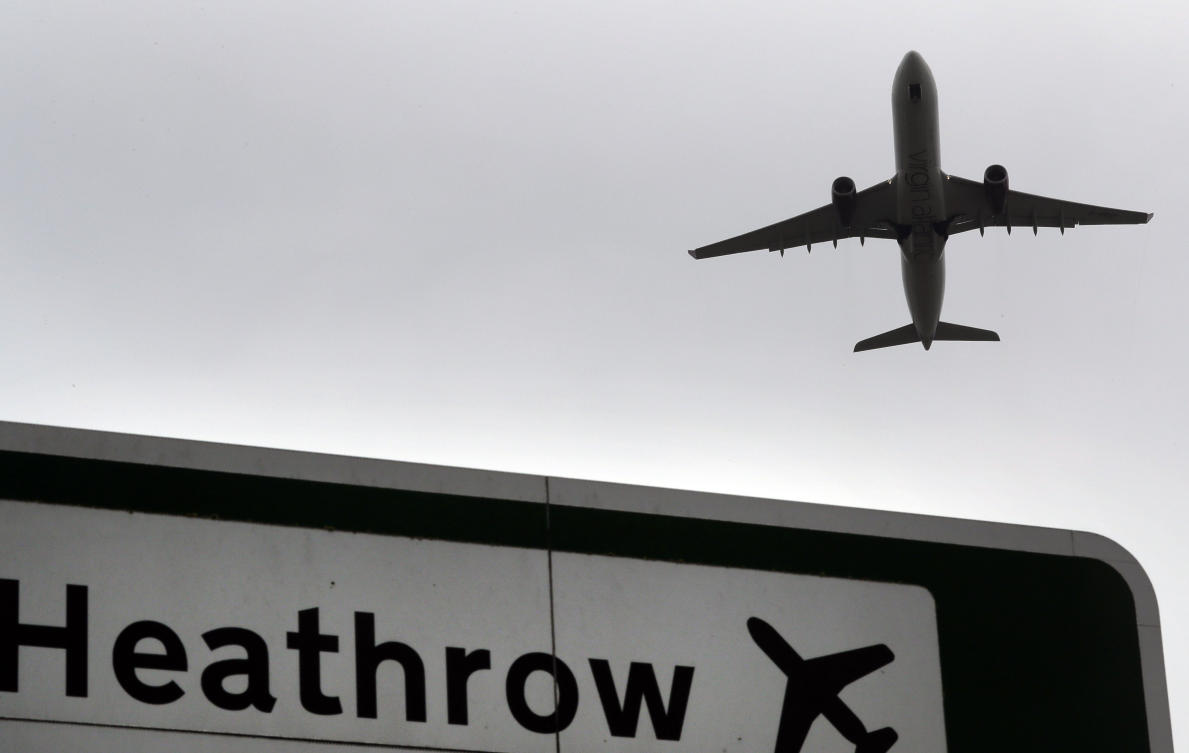 FILE - A plane takes off over a road sign near Heathrow Airport in London. (AP)