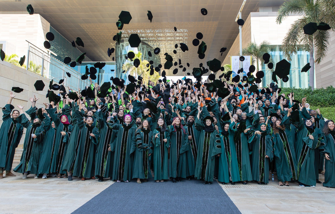 KAUST doctoral candidates throw their hats to the sky during a playful group photo during their graduation. (KAUST Photo)