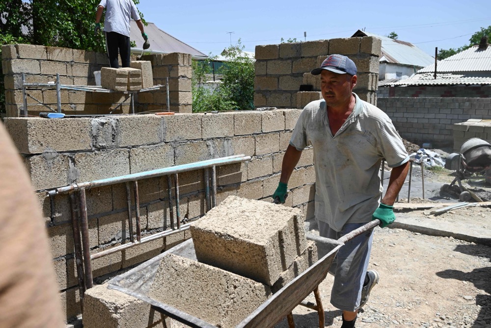 Workers build a house with rice construction blocks, made mostly of rice husks - a byproduct of rice processing, in the Kyzyl-Kiya village in southern Kyrgyzstan. (AFP)