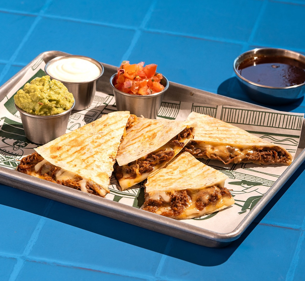 Taqado's open kitchen buzzes with efficiency, offering a lively backdrop for quick lunches or relaxed dinners. (Instagram: @Taqadomexicankitchen.ksa)