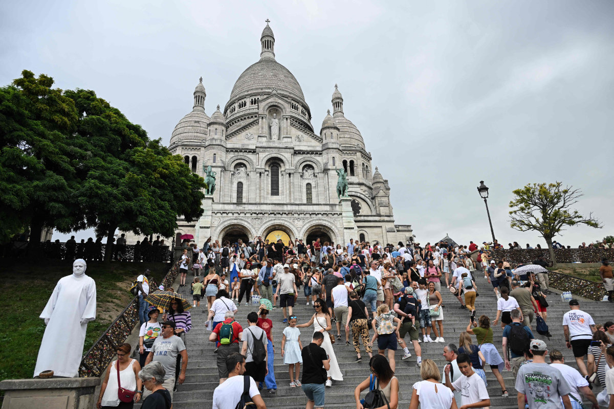 Tourists climb the stairs leading to the Sacre-Coeur Basilica on Montmartre hill in Paris on August 13, 2025. (AFP)