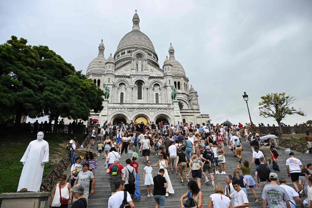 Tourists climb the stairs leading to the Sacre-Coeur Basilica on Montmartre hill in Paris on August 13, 2025. (AFP)