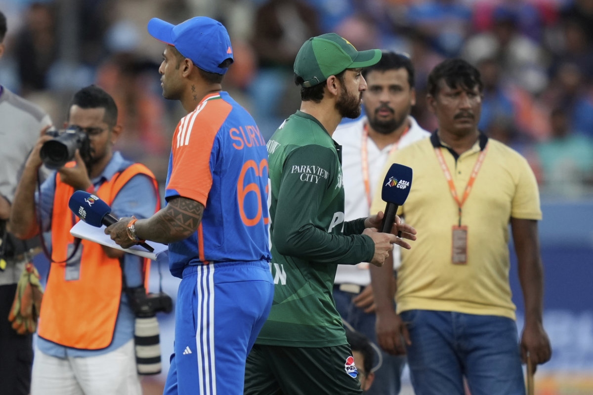 Pakistan's captain Salman Agha, right, walks past India's captain Suryakumar Yadav after the coin toss ahead of the Asia Cup cricket match between India and Pakistan at Dubai International Cricket Stadium on Sept. 14, 2025. (AP)