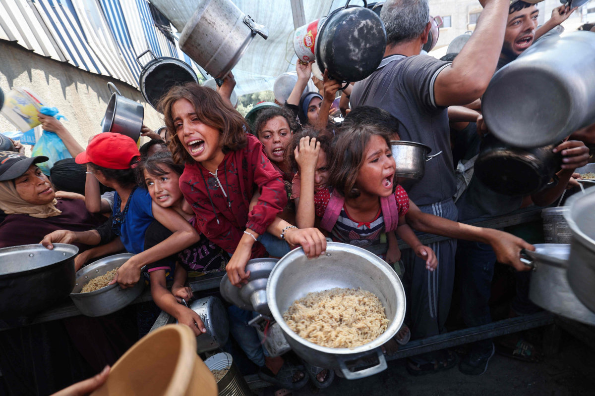 Palestinians queue for food from a charity kitchen in the Nuseirat refugee camp in Gaza Strip on Sept. 4, 2025. (AFP)