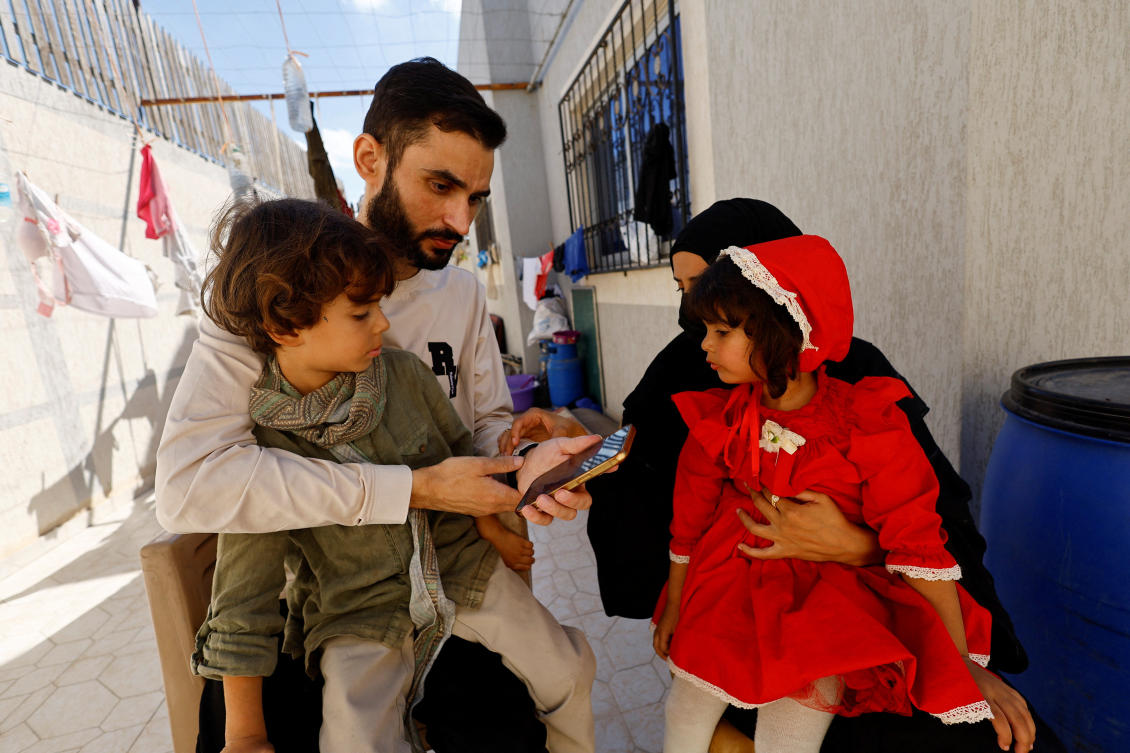 Freed Palestinian detainee Shadi Abu Sido sits with his wife Hanaa Bahlul and their children at their home in Nuseirat, central Gaza Strip, after he was released from Israeli detention. (REUTERS/File)