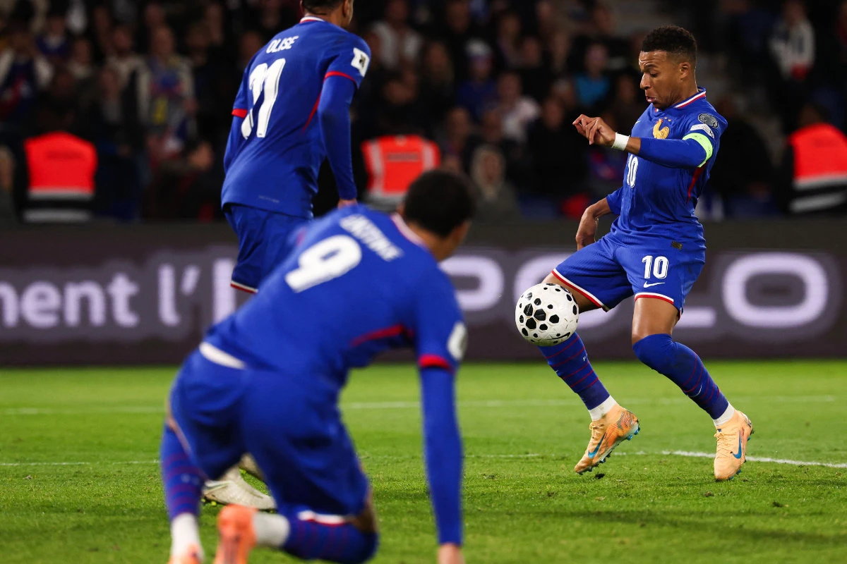 France’s forward Kylian Mbappe (R) shoots and scores his team’s third goal and the 400th goal of his career during the 2026 World Cup qualifiers Europe zone group D match between France and Ukraine at the Parc des Princes stadium in Paris on Thursday. (AFP)