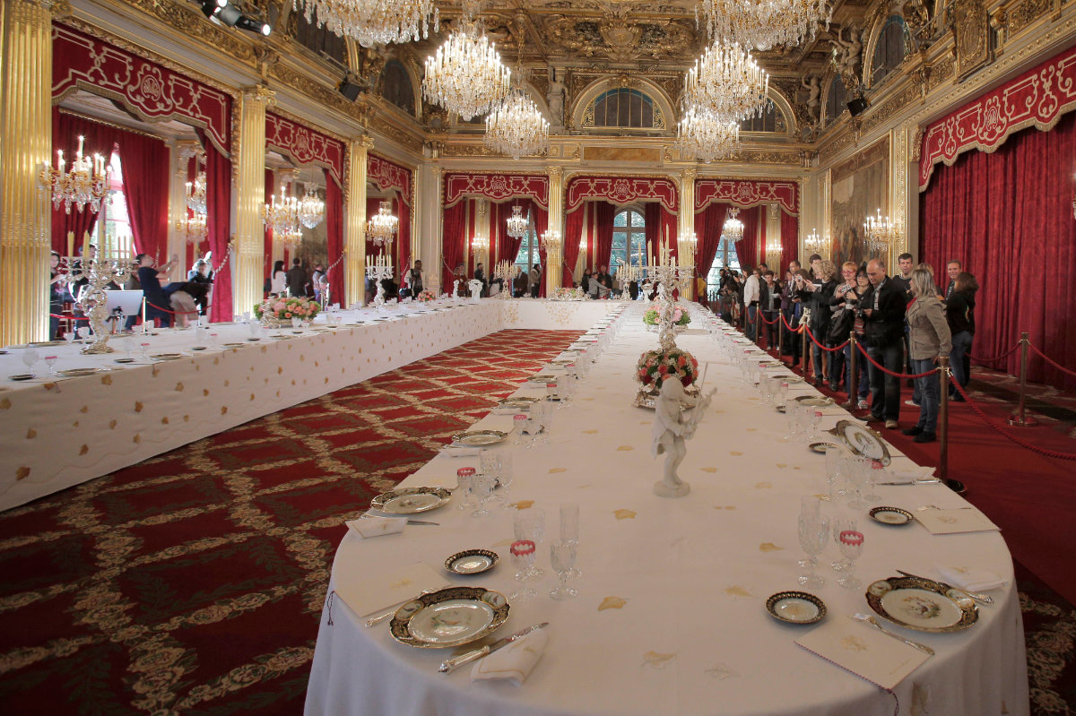Visitors view a table dressed with plates and glasses for official dinners at the Élysée Palace in Paris on Sept. 15, 2012. France's national buildings and administrations were opened to the public for Heritage Days weekend. (AP Photo/File)
