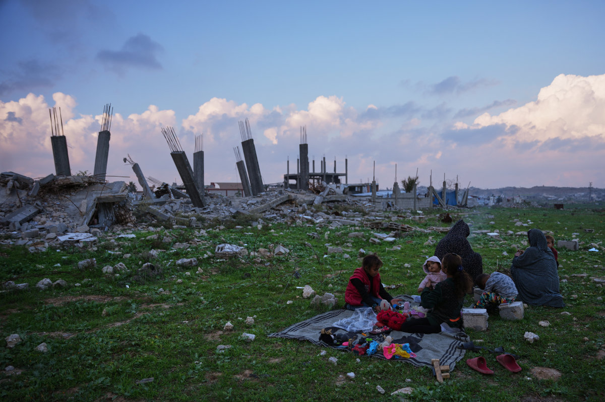 Members of the Abu Rukba family sit together near destroyed buildings in Nuseirat, Gaza Strip on Dec. 26, 2025. (AP)