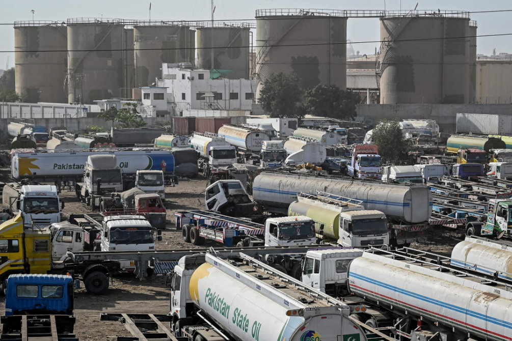 Oil tanker trucks stand parked near an oil storage terminal in Karachi as global energy markets face disruptions. (AFP)